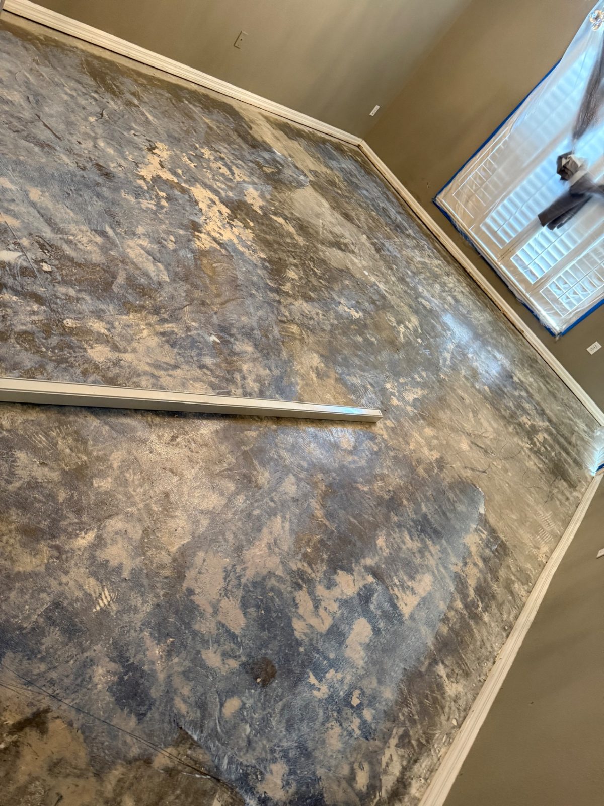 Uneven concrete slab leveled with self-leveling concrete — before