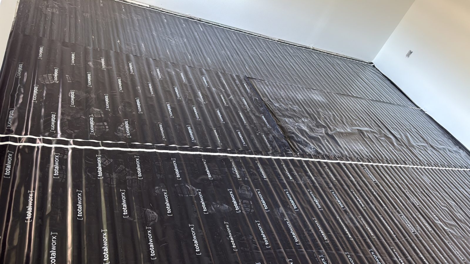 Subfloor prepped with underlayment, then finished with luxury vinyl plank — before